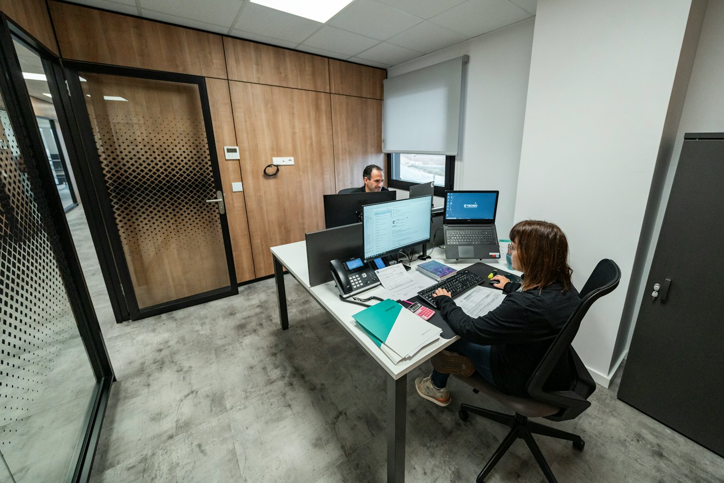 Zwei Fachleute arbeiten an Computern in einem modernen Büro.